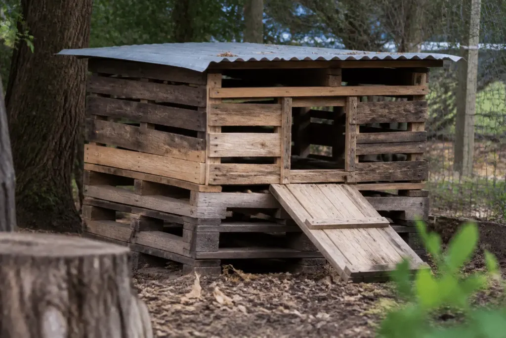 Palettes bois empilees formant structure poulailler rustique